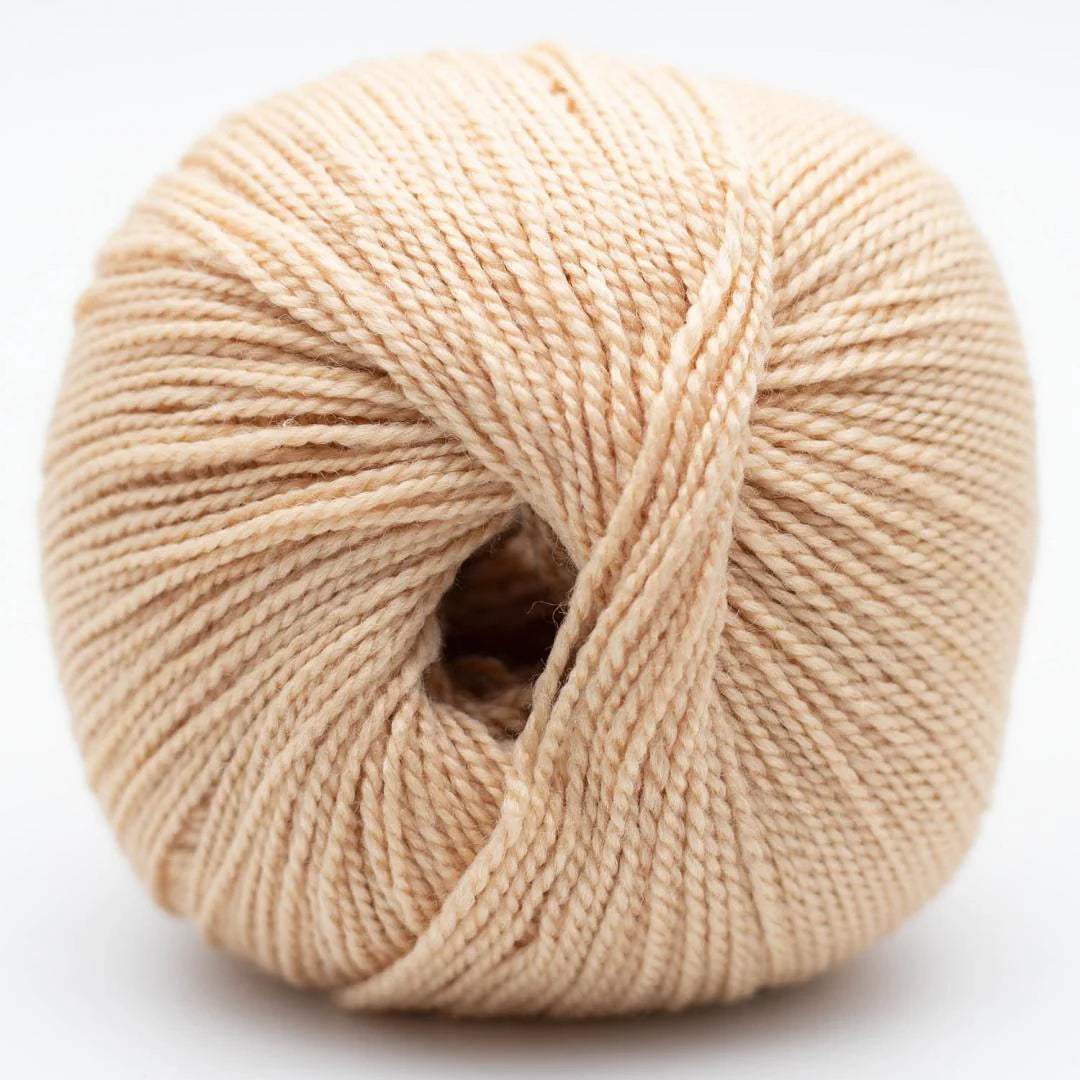 Wollknäuel in beigem Naturton mit gleichmäßiger Strickgarn-Textur und Mittelöffnung