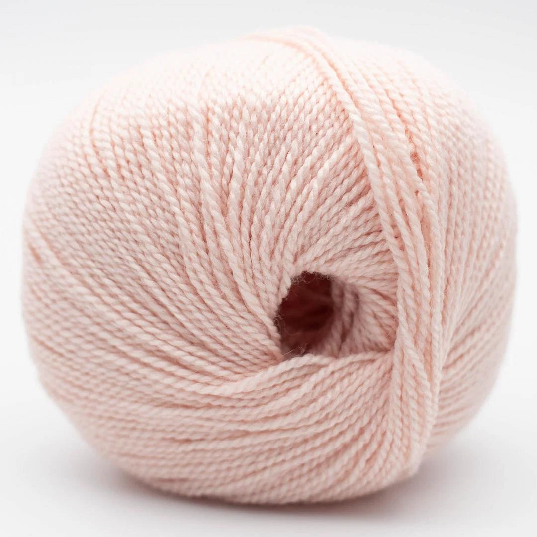 Wollknäuel in hellem rosa mit feiner Strickgarn-Textur und Öffnung in der Mitte