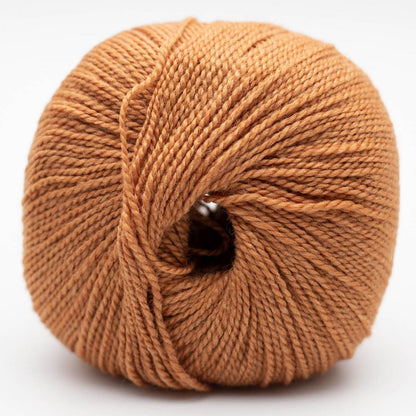 Wollgarnknäuel in warmem Orange, geflochtene Struktur, innen mit Ansatzloch