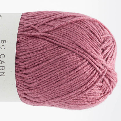 Garnknäuel in fliederfarbenem Rosa, gedrehte Strickoptik auf der Spule