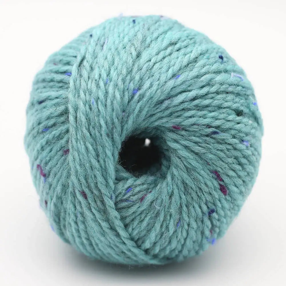 Garnknäuel in Türkis mit lila und blauen Sprenkeln, zentrales Loch der Wicklung