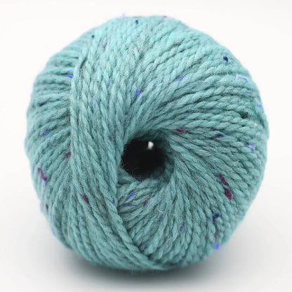 Garnknäuel in Türkis mit lila und blauen Sprenkeln, zentrales Loch der Wicklung