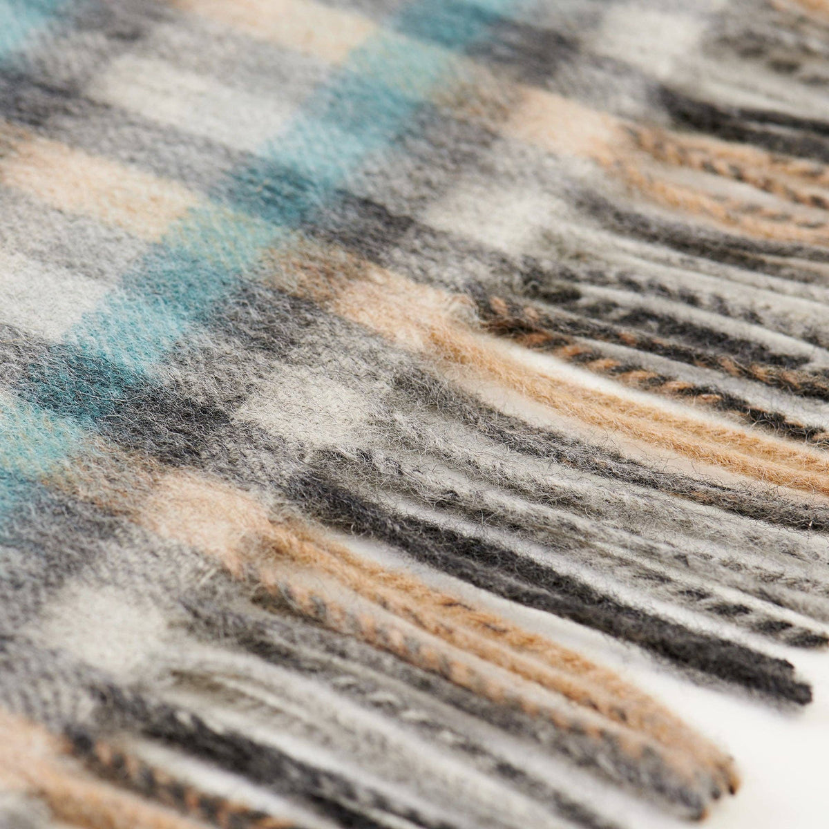 Detail Lammwoll-Schal: weiche Webstruktur in Grau, Beige und Blau mit Karo-Muster